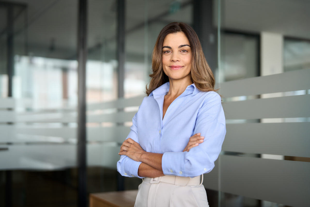 A female person standing in an office with crossed arms
